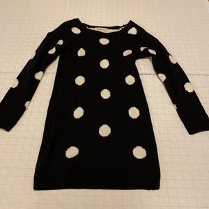 Black, kitted dress with white polka dots, thigh length.